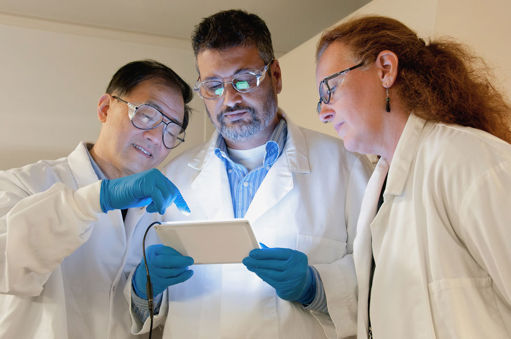 Group of scientist reviewing data on a tablet